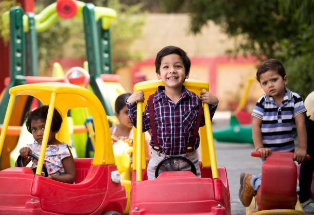 Preschool boys and girls having fun playing on toy car and rocking horse