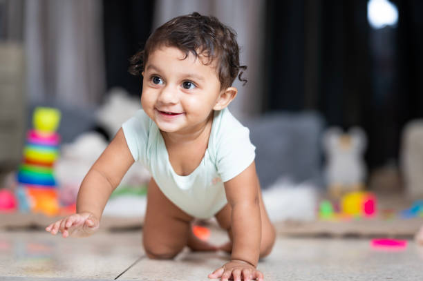 Baby crawling and laughing on the floor at home